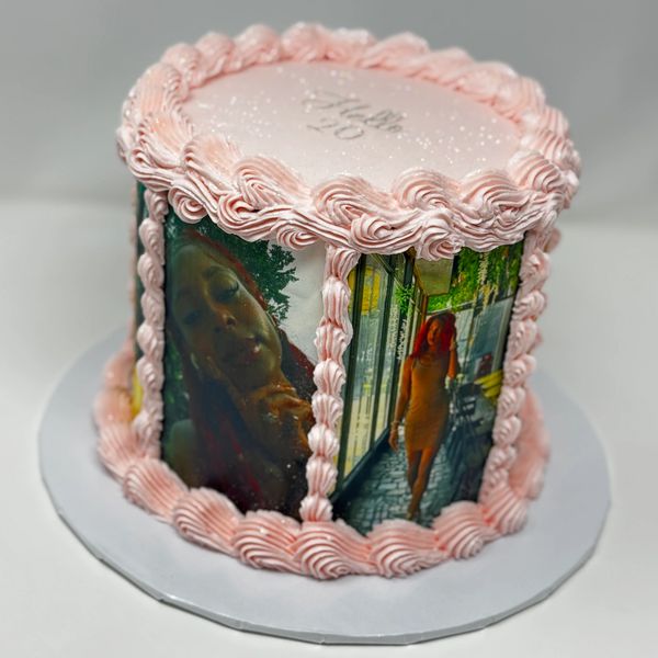 Pink cake decorated with personal photos and icing.
