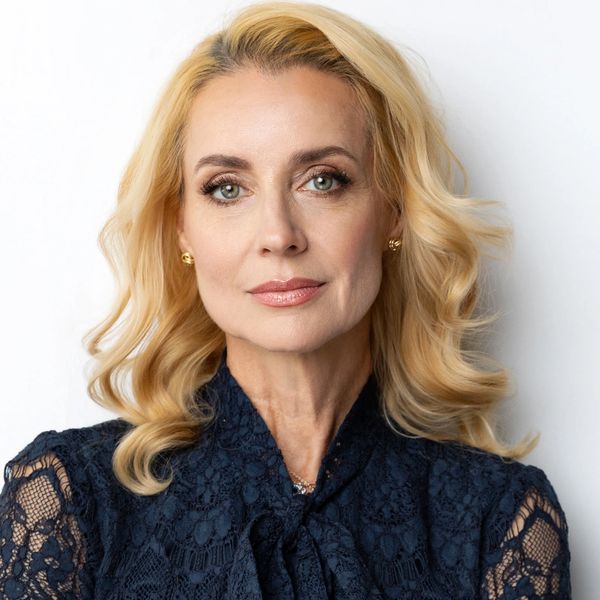Elegant woman with blonde hair and lace blouse.