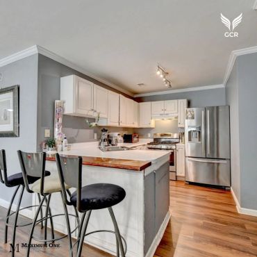 Cocina moderna con barra y taburetes.