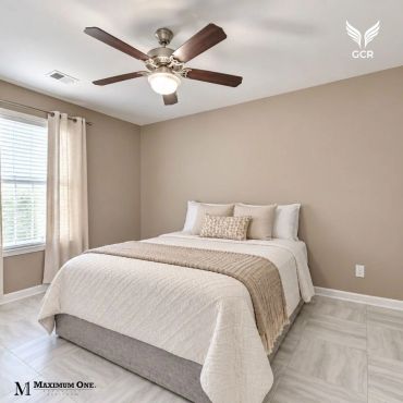 Dormitorio minimalista con cama doble y ventilador de techo.