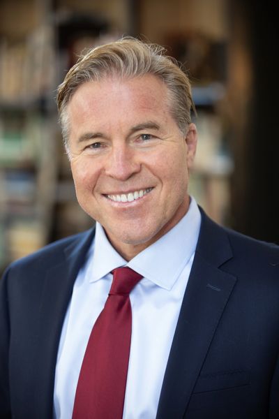 Smiling man in business suit with red tie.