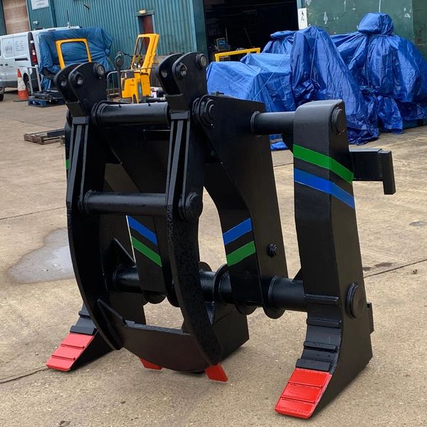 Heavy-duty black metal grapple attachment with red tips and colored stripes.