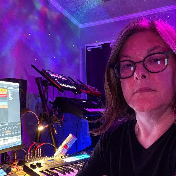 Person in a music studio with colorful lighting.