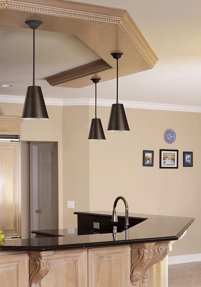 Modern kitchen with pendant lights and black countertop.