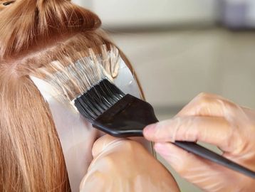 Hair coloring being applied with a brush.