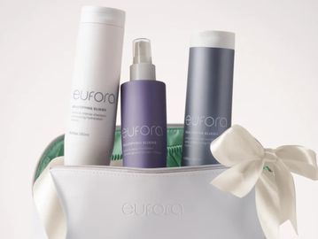 Three Eufora hair care products in a white pouch with a bow.