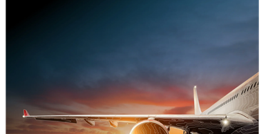 Airplane on runway during a colorful sunset with illuminated engine.