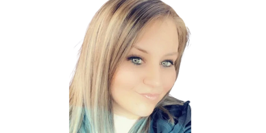Close-up of a woman with blonde and blue-tipped hair smiling subtly.