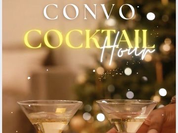 Two cocktail glasses clinked together in a cozy, festive setting.