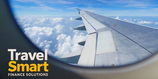 View from an airplane window with clouds and blue sky, featuring 'Travel Smart Finance Solutions' text.