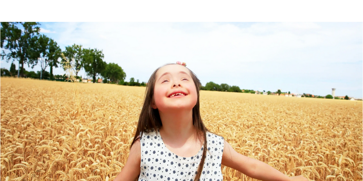 Downs Syndrome girl in field smiling