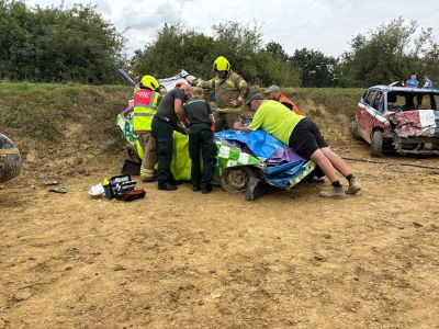 Emergency responders attending to a damaged race car.