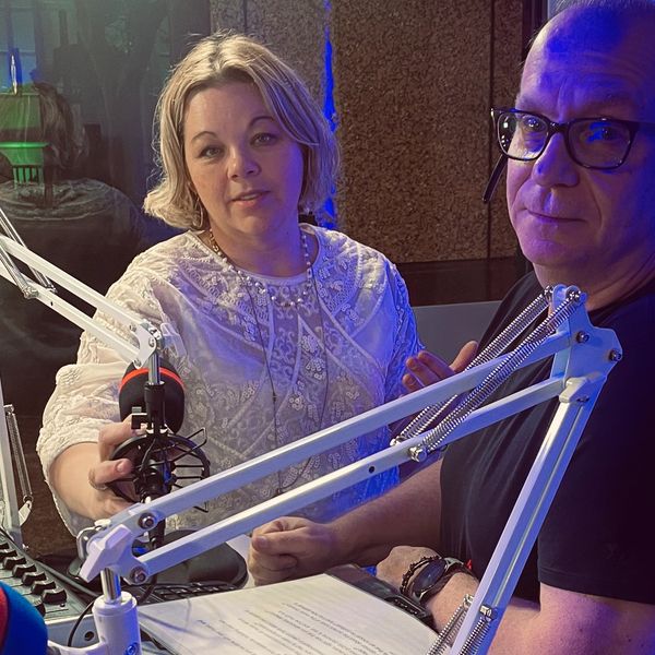 Two people in a recording studio with microphones.