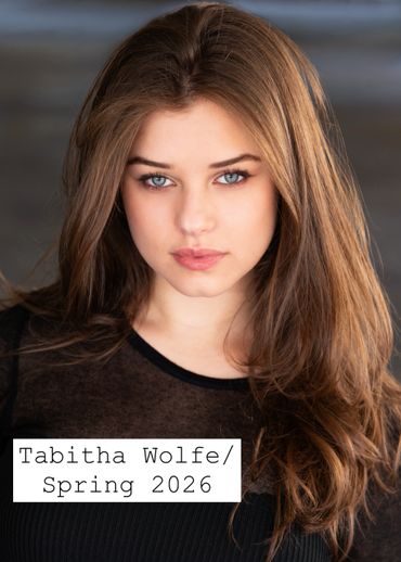 Portrait of a young woman with long brown hair and blue eyes.