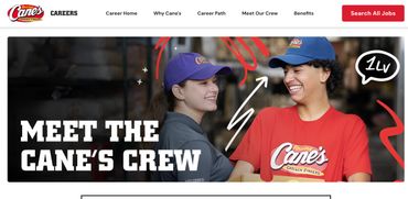 Two Raising Cane's employees smiling and interacting, promoting team spirit.