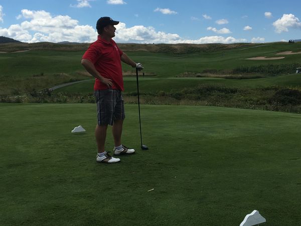 Golfer looks off in the distance after taking a shot.