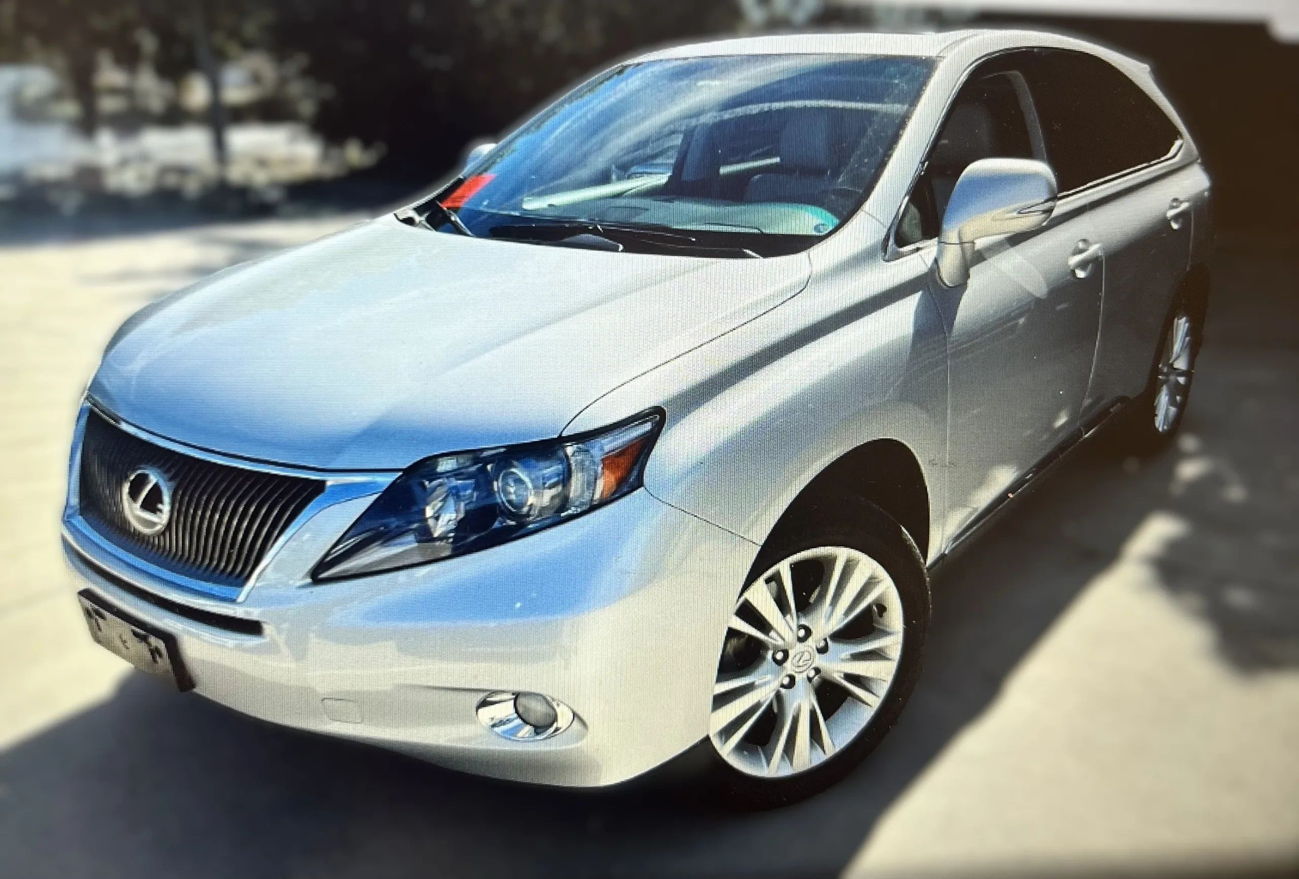 Silver Lexus SUV parked outdoors on a sunny day.