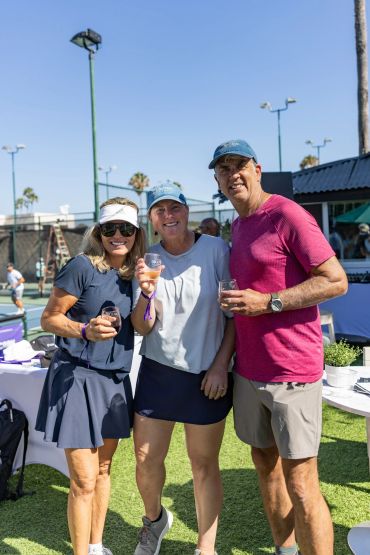 Three people enjoying drinks outdoors on a sunny day.