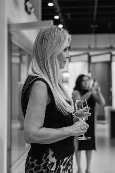 Black and white image of a woman holding a wine glass.