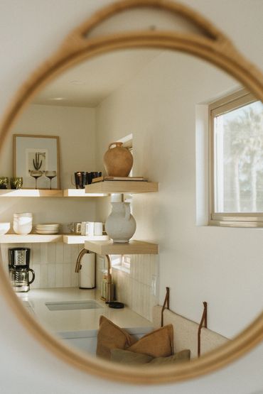 Reflection of a cozy kitchen corner in a round mirror.