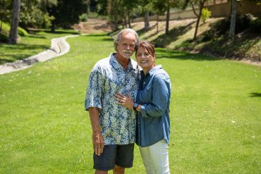 Smiling senior couple standing together outdoors.