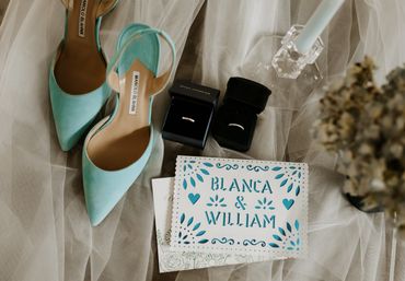 Wedding details with shoes, rings, and invitation.