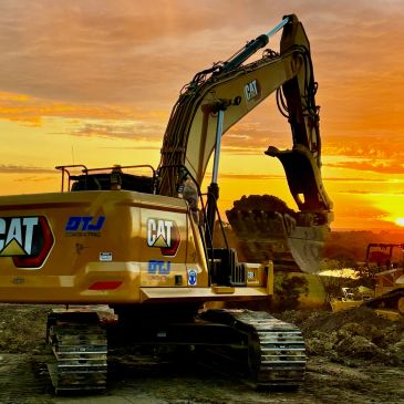Excavator working at sunset on a construction site.