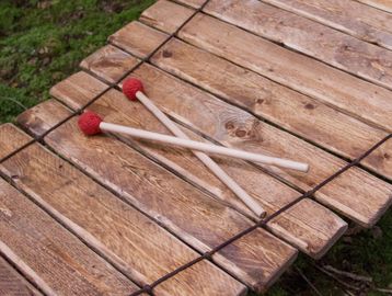 Wooden xylophone with red-tipped mallets.