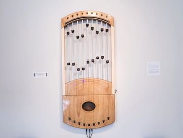 Wooden stringed musical instrument mounted on a wall.