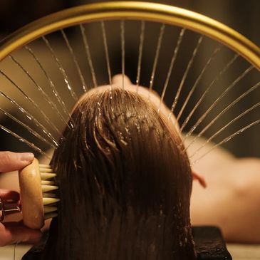 Person getting hair washed and brushed under water.