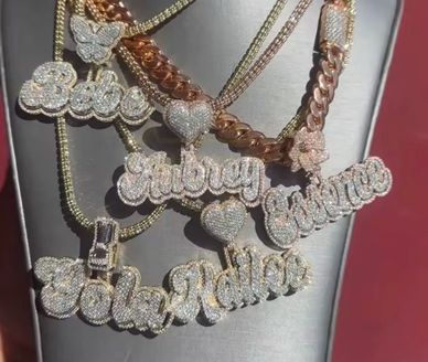 Diamond-studded name necklaces on display.
