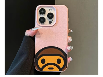Hand holding a phone with a pink case and cartoon design.