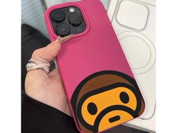 Hand holding a phone with a colorful monkey-themed case.