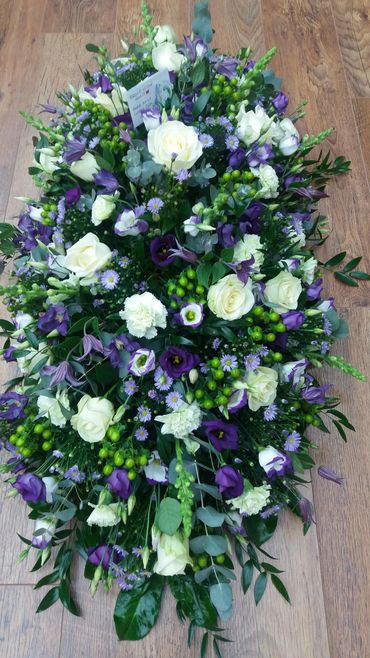 Classic double ended coffin spray in purples, lilacs and whites.