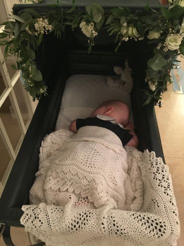 Flowers decorated around the pram ready for a christening.