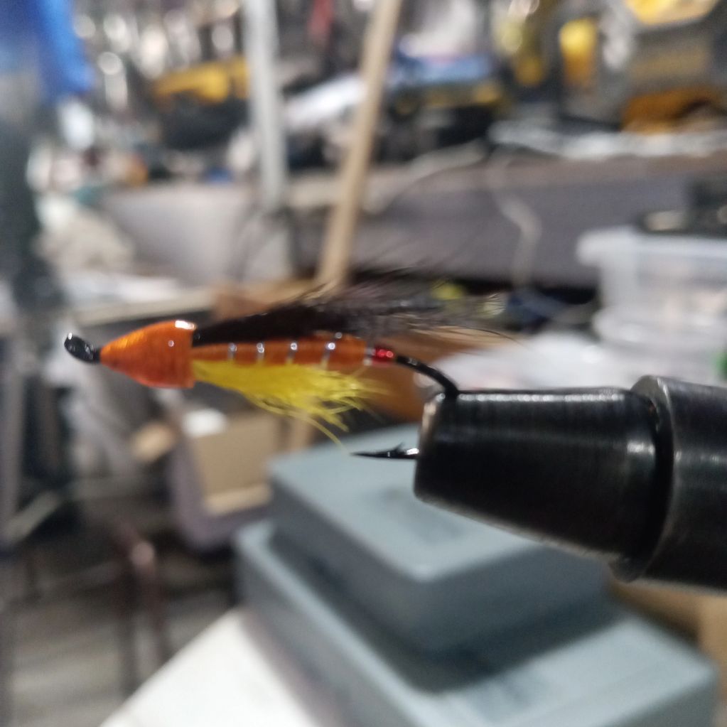 Close-up of a hand-tied fishing fly held in a vise.
