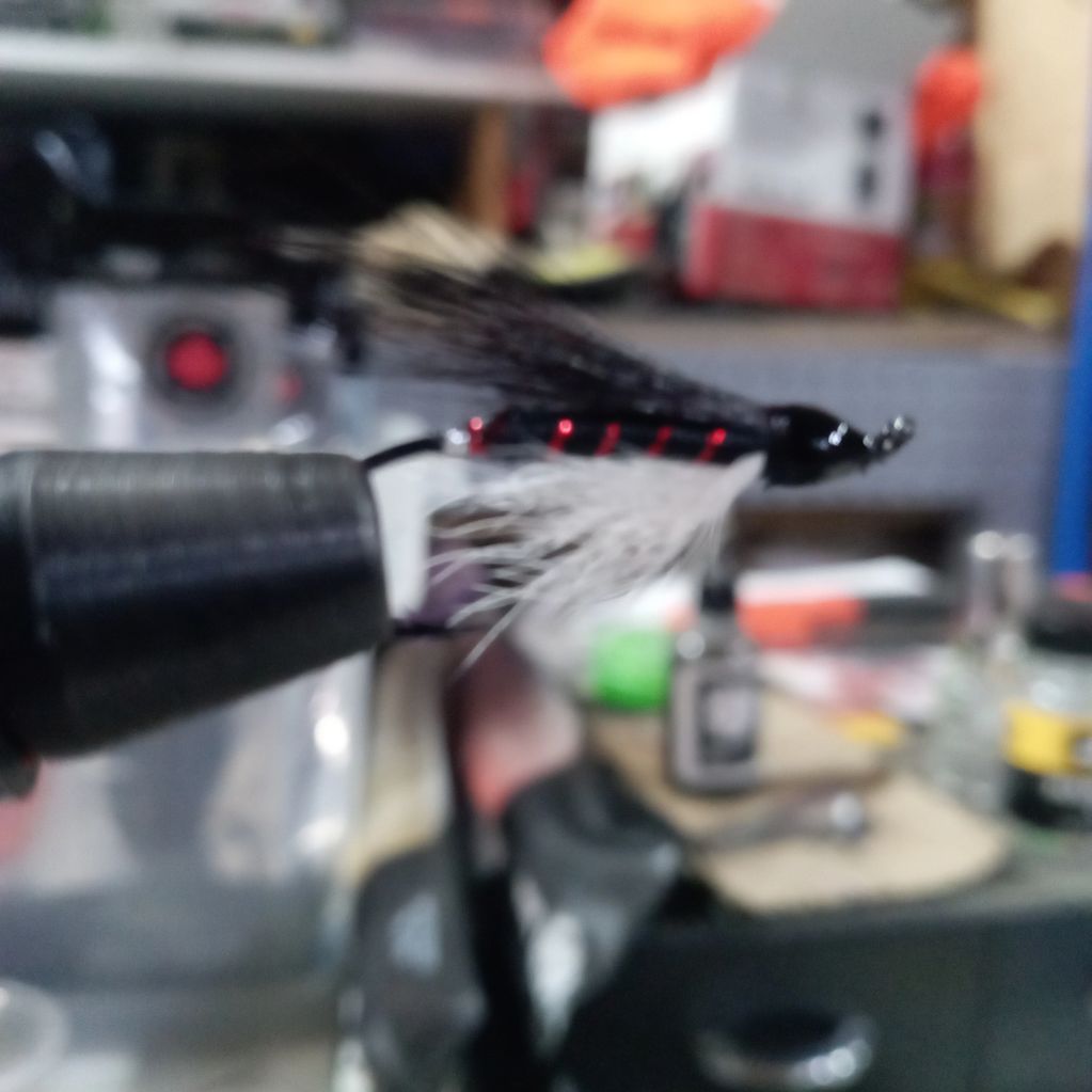 Close-up of a fishing fly lure in a workshop.