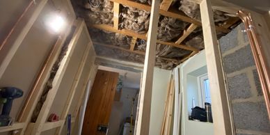 Room under renovation with exposed ceiling insulation.