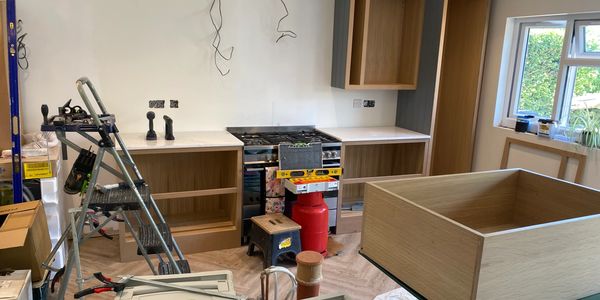 Kitchen under renovation with tools and cabinets.
