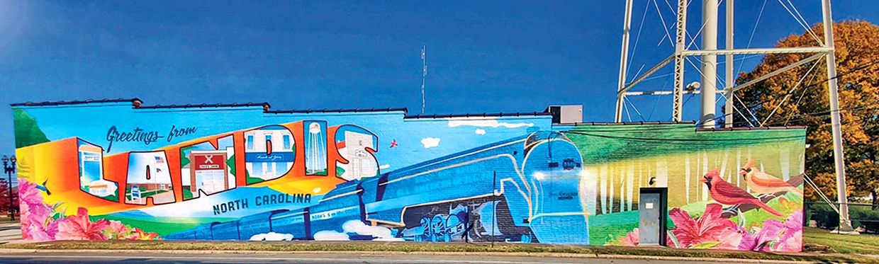 Colorful mural with 'Landis North Carolina' and a blue train on a building.