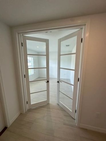 White double glass doors opening into a bright room.