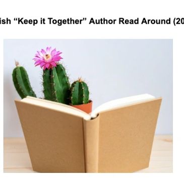 A blooming cactus with a pink flower behind an open book on a wooden surface.