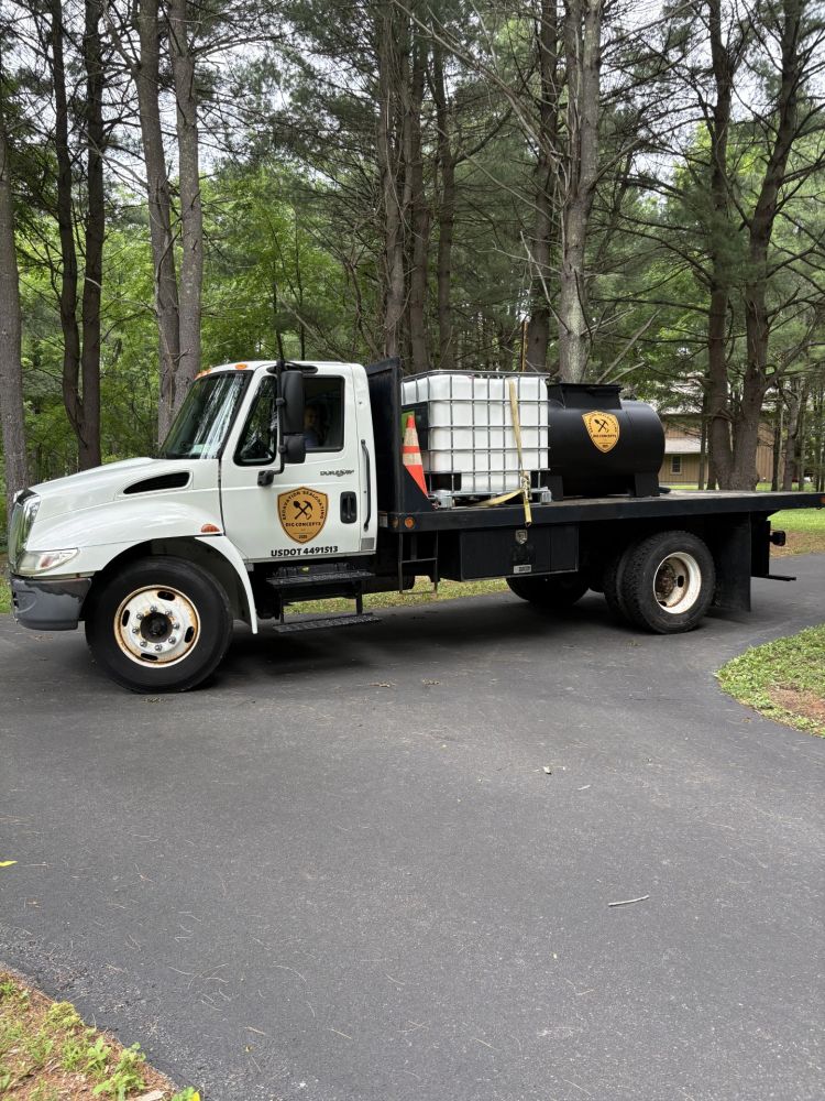 Flatbed truck with containers in wooded area.
