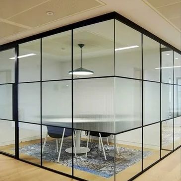 Modern office meeting room with glass walls and frosted privacy panels.