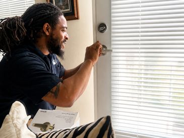 Man happily unlocking a door with a new lock installation.