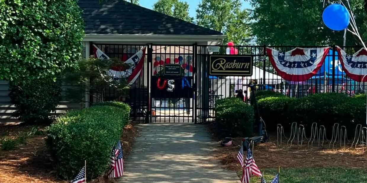 Entrance gate decorated with patriotic bunting and flags for a US celebration.