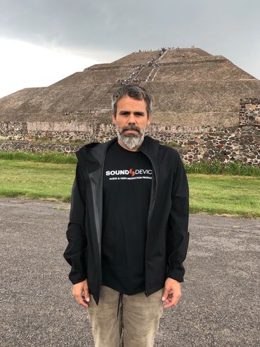 Man standing in front of the Pyramid of the Sun in Teotihuacan, Mexico.