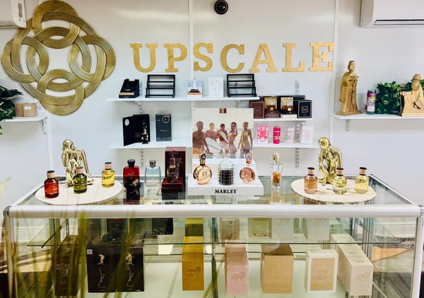 A classy display of luxury perfumes under the sign 'UPSCALE'.