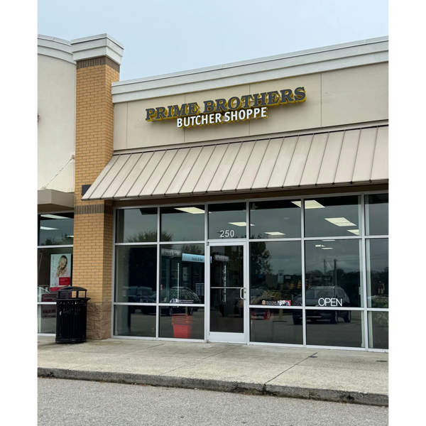 Front view of Prime Brothers Butcher Shoppe with glass doors and an open sign. Fresh Prime butcher shop in north carolina with the best quality