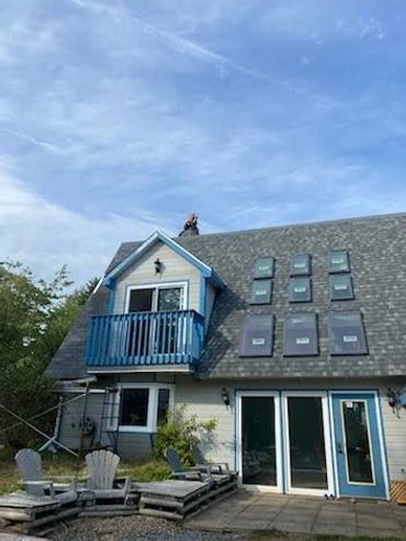 House with a balcony and solar panels on the roof.